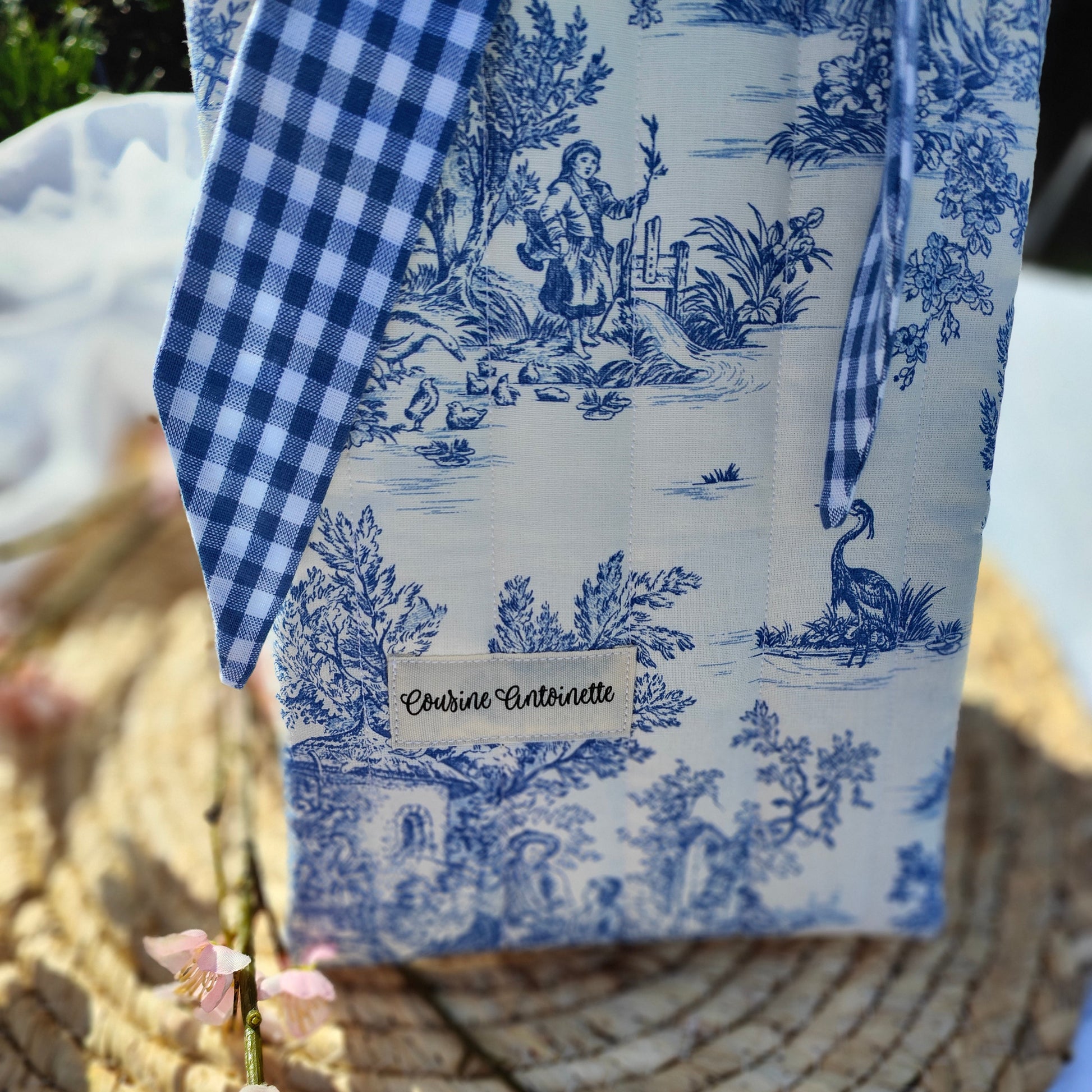 Housse de livre broché Céleste artisanale matelassée, motif bleu ciel, doublée vichy bleu, fermeture nouettes, fait main Angers
