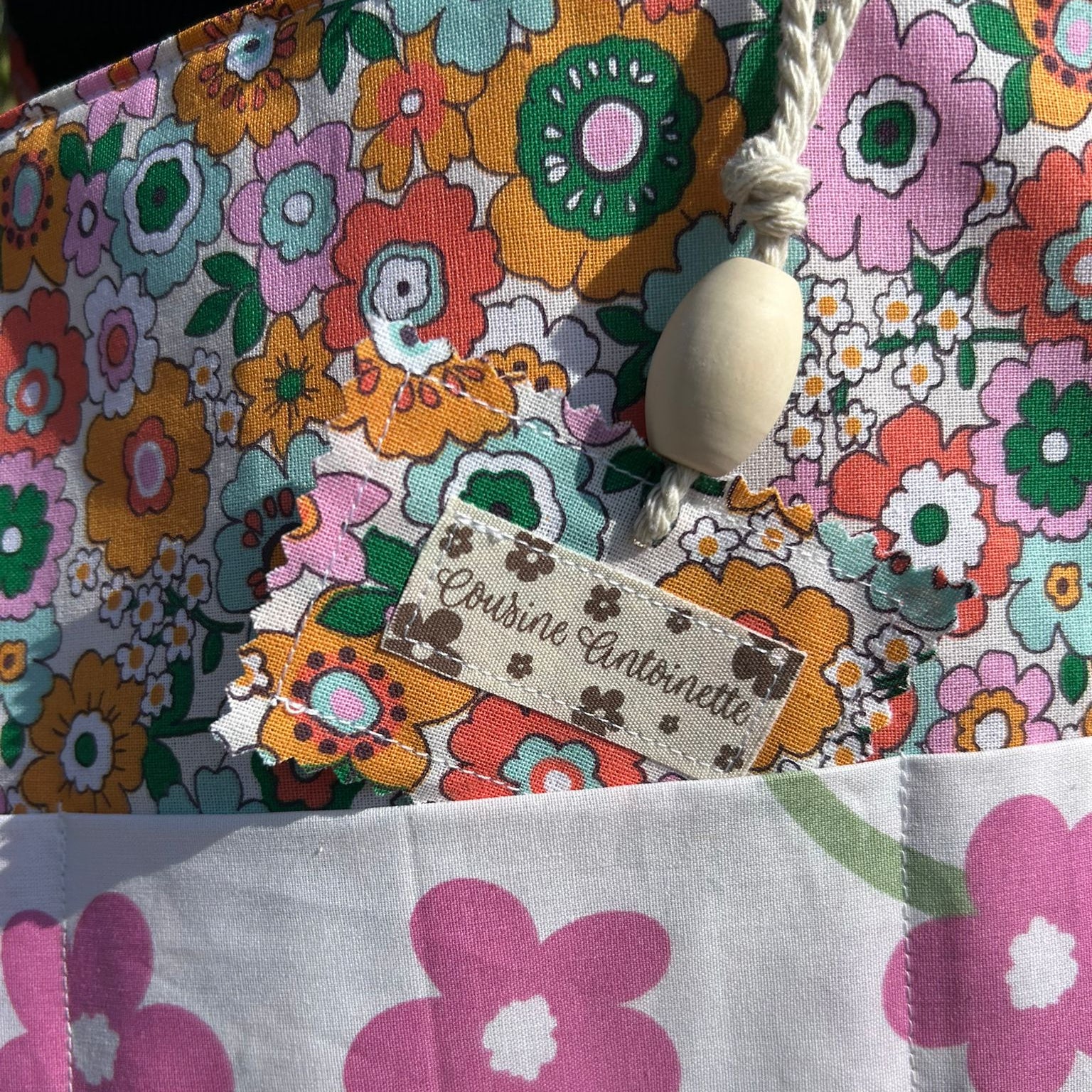Sac cabas Barnabé de Chéribibi par Cousine Antoinette, en tissu coloré avec poignées en cuir et motif floral visible.