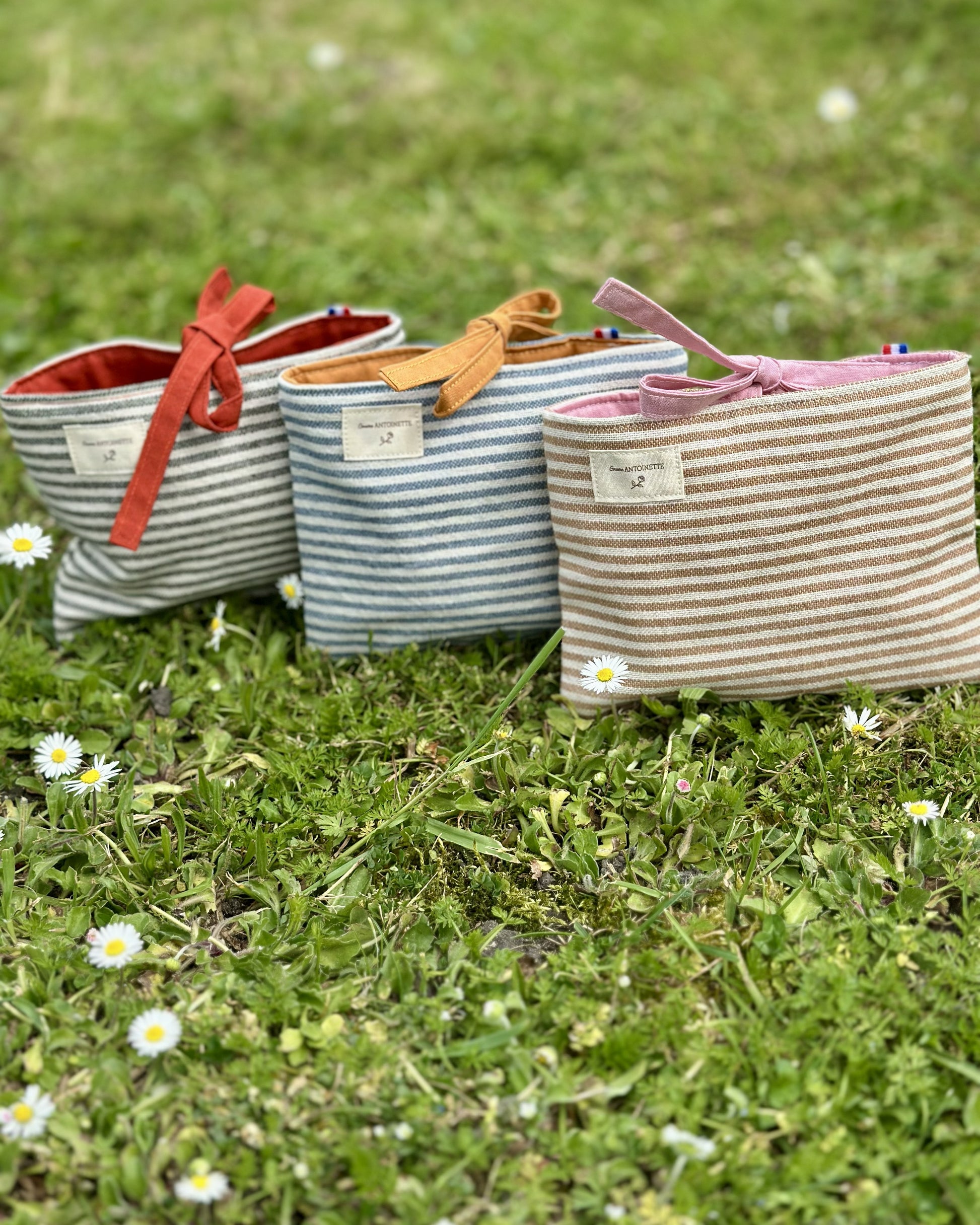 Collection pochettes plates Deauville – 3 coloris Safran, Curry et Blush en coton rayé Oeko-Tex, fermeture à nouettes, cousues main en France – Cousine Antoinette
