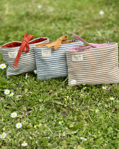 Collection pochettes plates Deauville – 3 coloris Safran, Curry et Blush en coton rayé Oeko-Tex, fermeture à nouettes, cousues main en France – Cousine Antoinette
