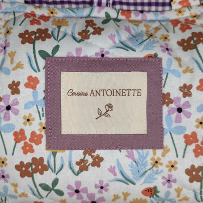 Étiquette Cousine Antoinette sur pochette Leone Lilas, accessoire artisanal en coton certifié Oeko-Tex
